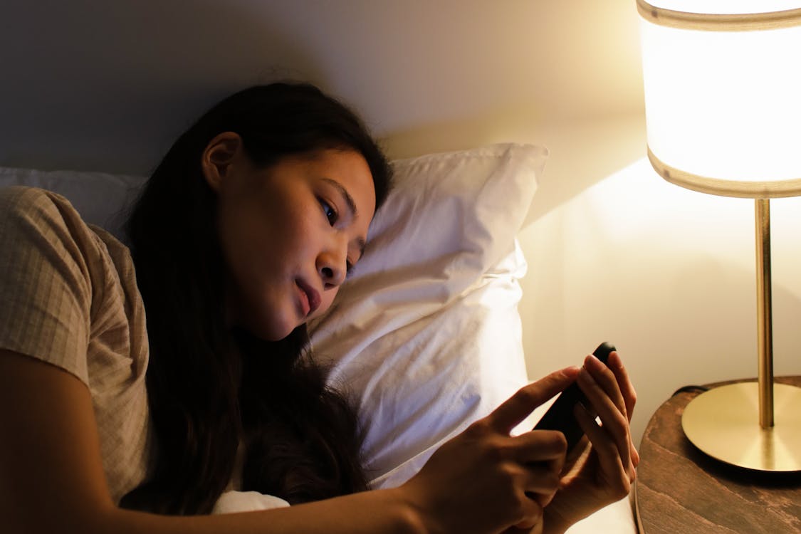 Person alone at night scrolling through their phone